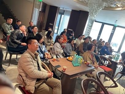 A group of people sitting around a table Description automatically generated with medium confidence